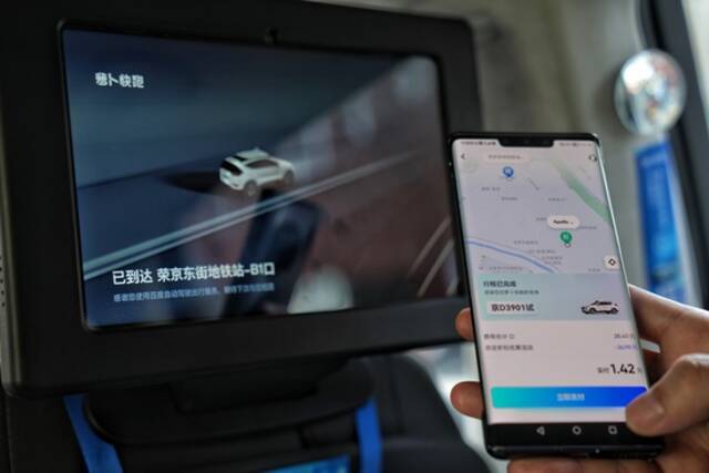 一名在北京亦庄乘坐自动驾驶出租车的乘客准备付车费。新华社记者彭子洋摄