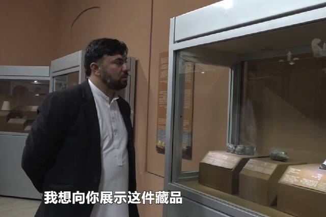 阿富汗国家博物馆馆长拉希米对新华社记者讲解阿富汗国家博物馆的重要展品。视频截图