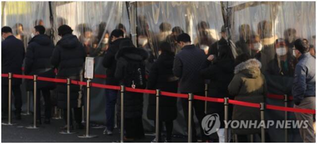 （12月20日，在设于首尔站广场的临时筛查点，韩国市民排长队等待接受新冠检测。图自韩联社）