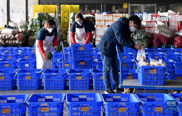 陕西米禾供应链管理股份有限公司的工作人员在分装即将配送的蔬菜（12月19日摄）。新华社记者刘潇摄