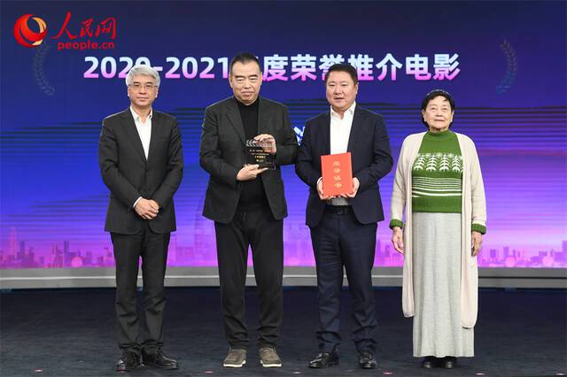 著名电影艺术家、事业家王晓棠（右一），人民网总编辑罗华（左一）为于冬（右二）、陈凯歌（左二）颁发2020-2021年度荣誉推介电影