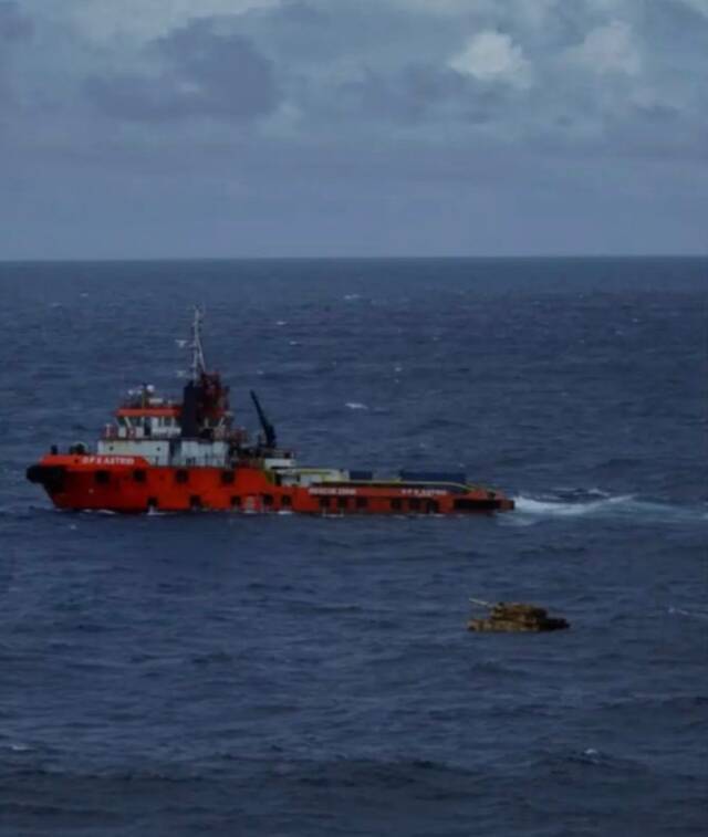 一艘拖船试图对浮在水面的“坦克”进行打捞