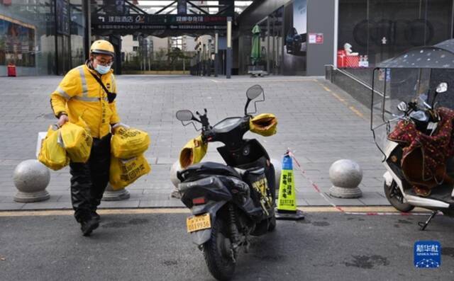  12月26日，外卖员在西安市南门外路边忙碌。新华社记者陶明摄
