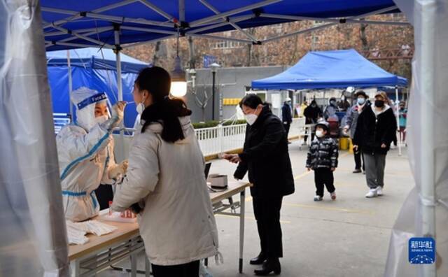 12月27日，在西安市碑林区张家村街道太白社区，居民在接受核酸检测。新华社记者陶明摄