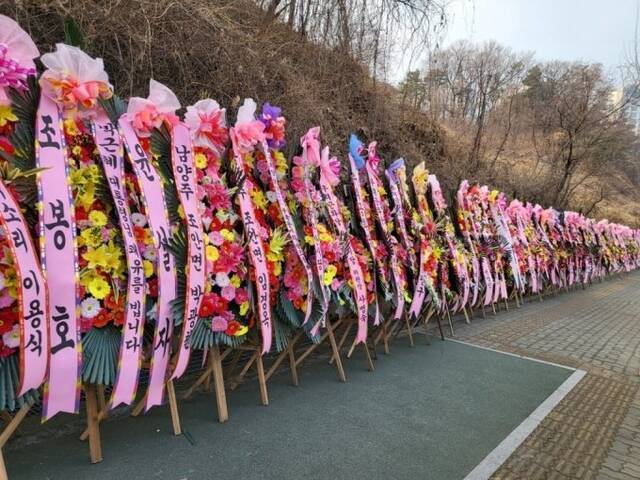 朴槿惠获释后暂不出院，医院门口粉丝送的花环一眼望不到头