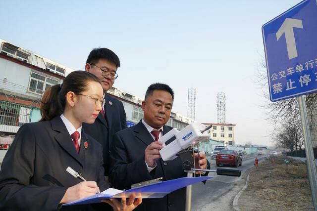 图为检察官对修复后的道路进行空气质量检测。