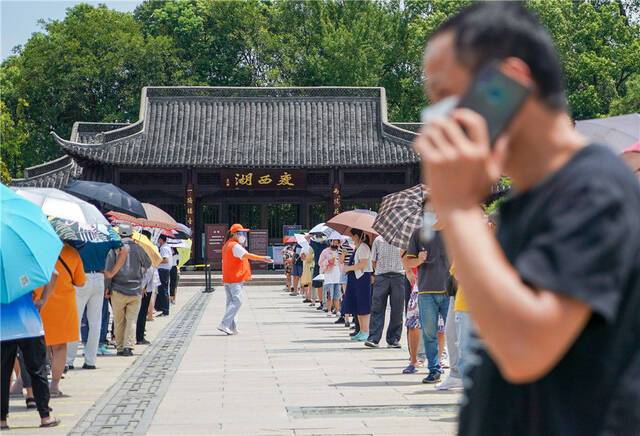 市民在扬州市瘦西湖街道五亭社区瘦西湖西门采样点排队，准备进行核酸检测（8月7日摄）。新华社记者李博摄