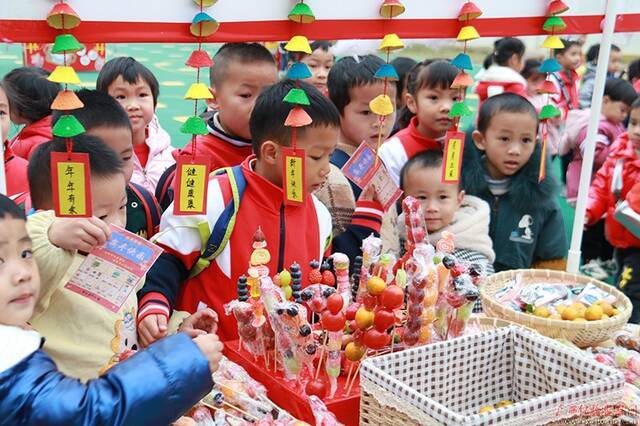 元旦将至，蒙山县幼儿园举办逛庙会游园庆祝元旦活动，孩子们逛庙会，凭兑换卡换取糖葫芦，一张张笑脸、一阵阵歌声，都洋溢着幸福快乐。（蒙山县纪委监委张霖蔓/摄）