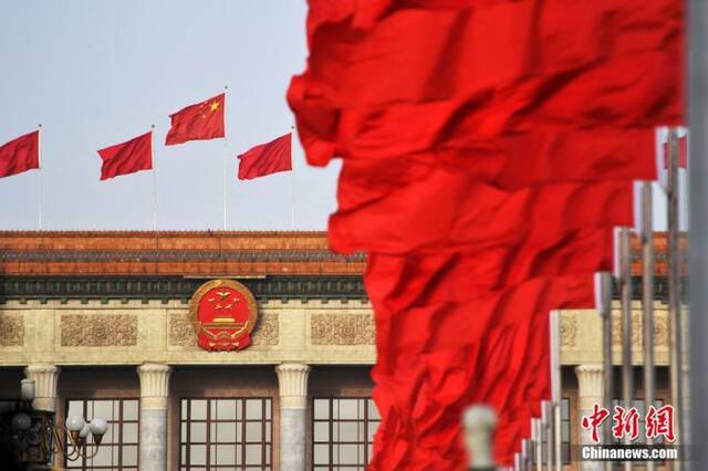 资料图：人民大会堂外，红旗迎风飘扬。中新社记者金硕摄
