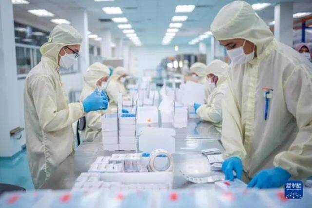 2021年10月5日，在马来西亚吉隆坡郊区的发马公司灌装工厂，工人包装本地灌装生产的中国科兴新冠疫苗。图：新华社