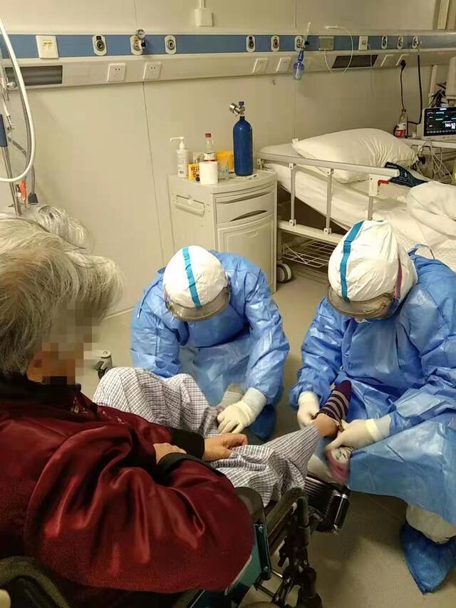 本轮疫情期间，医护人员为患者进行护理。北京地坛医院供图