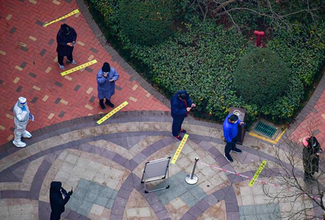  2022年1月4日，西安曲江新区一小区开展核酸筛查，参加居民严格保持间距。人民视觉图