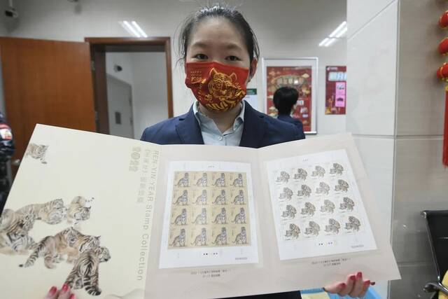 邮政工作人员展示虎年生肖邮票大版折