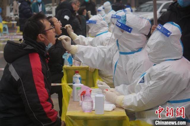 图为医务人员为郑州市民做咽拭子采样。韩章云摄