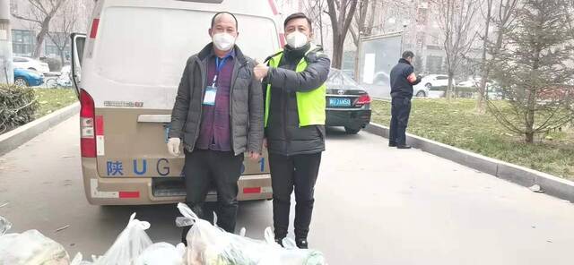 杨军（右）和为8号楼业主捐菜的超市老板张多平合影