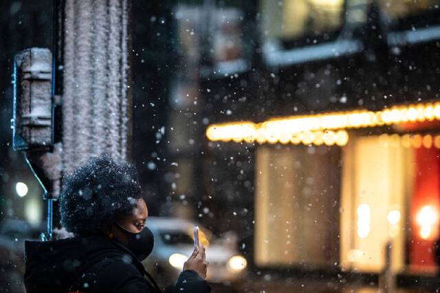 ↑2022年1月1日，在美国芝加哥，一名女子等待过马路。新华社发（文森特·约翰逊摄）