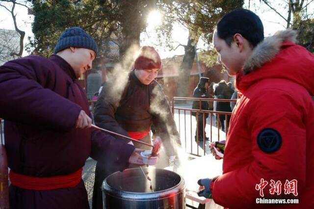 资料图：腊八节当日，雍和宫的工作人员熬制腊八粥免费发放。中新社记者韩海丹摄