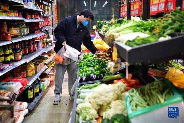 1月7日，西安曲江新区一小区超市内，一名居民在选购菜品。新华社记者邵瑞摄