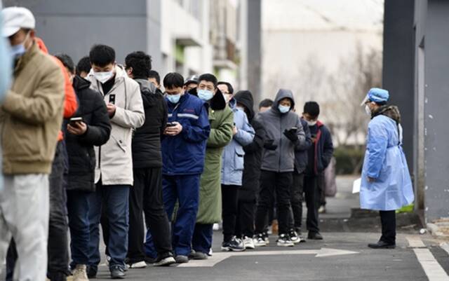 1月9日，在天津滨海高新区的一处核酸检测点，居民排队等待核酸检测。新华社图。