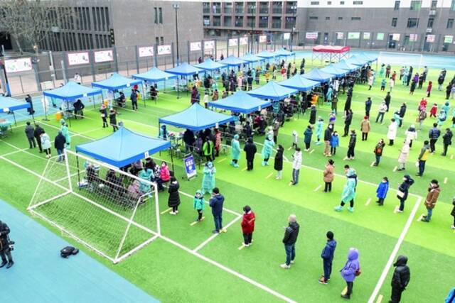 天津于9日、10日进行全员核酸检测。图为9日天津市民在南开区中营小学操场排队检测核酸。