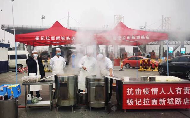 1月10日，杨记拉面新城路店的厨师们在核酸检测点旁做拉面。受访者供图