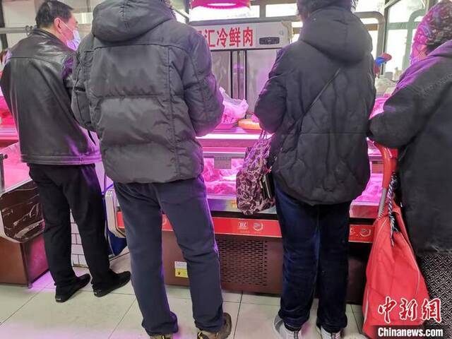 居民在猪肉摊前购买猪肉。中新网记者谢艺观摄