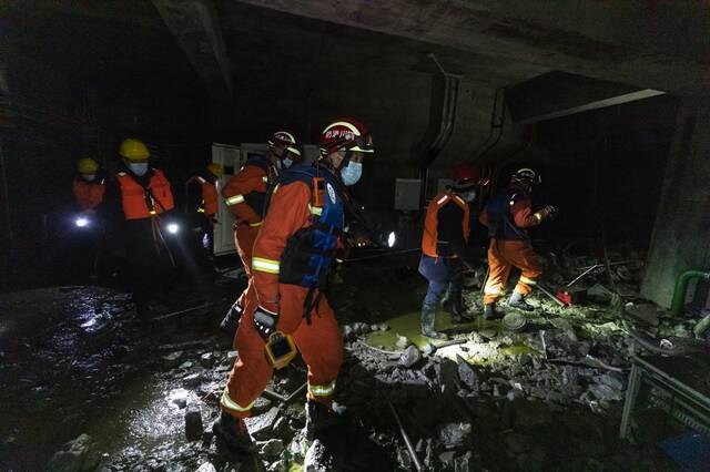 1月13日，救援人员在丹巴县章谷镇三岔河关州电站厂地下二层搜救。新华社图