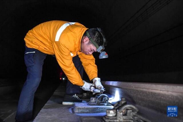 1月21日凌晨，工作人员对松动的轨道扣件进行加固。新华社记者曹祎铭摄