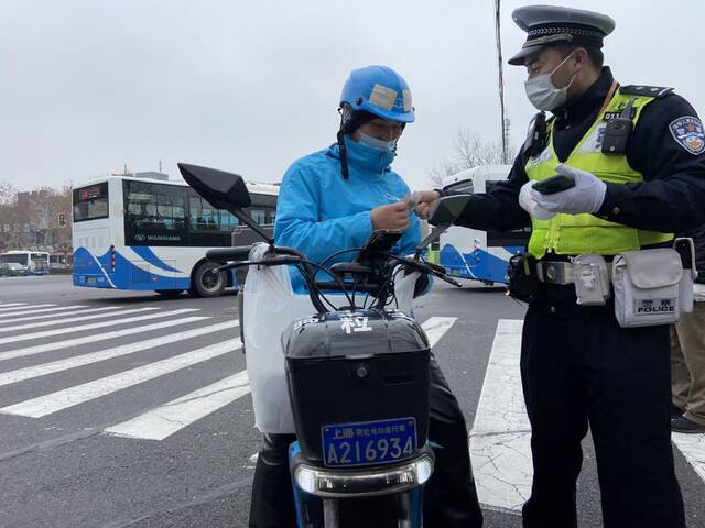 民警对未更换专用号牌的外卖员进行教育警告。本文图片均由澎湃新闻记者朱奕奕摄