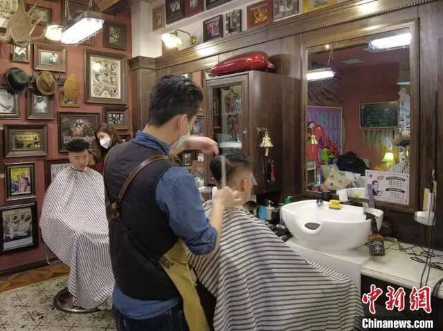 西安黑桃理发店内，顾客正在剪发。党田野摄