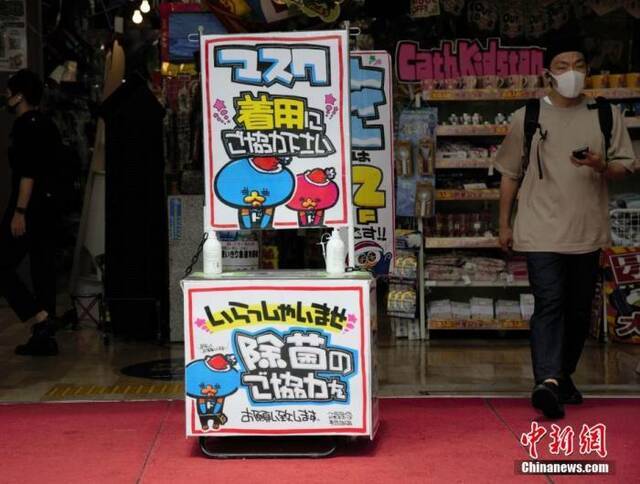 资料图：日本东京某商店在入口处以漫画形式提醒顾客采取戴口罩和除菌等防疫措施。中新社记者吕少威摄