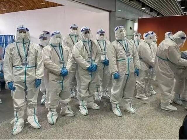 全身穿着白色防护服的工作人员迎接时事通讯社记者（图源：时事通讯社）