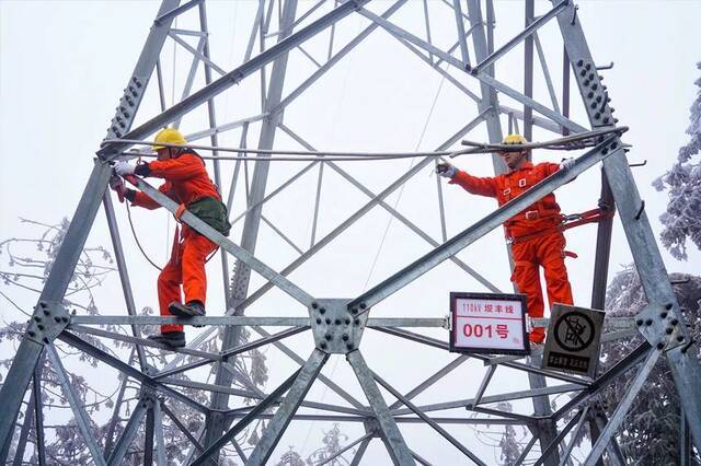 电力巡线工人对110千伏坝丰线1号铁塔覆冰进行测量罗一灵摄