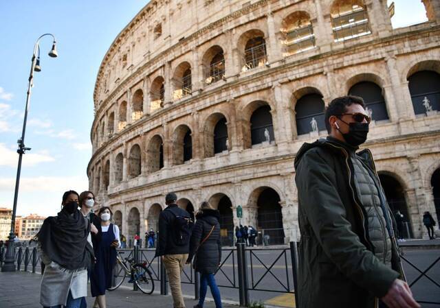 1月24日，人们佩戴口罩走过意大利罗马斗兽场。新华社记者金马梦妮摄
