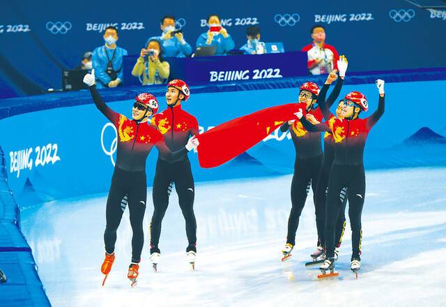 短道速滑混合团体接力比赛结束后，中国队选手举国旗绕场致谢。瞿芃摄