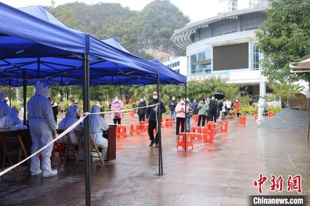 德保县民众冒雨接受核酸筛查。陈秋霞摄