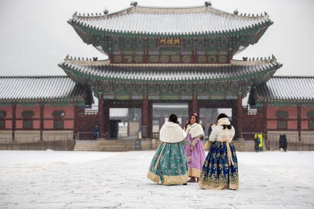 1月19日，在韩国首尔，游客在雪中游览景福宫。（新华社记者王益亮摄）