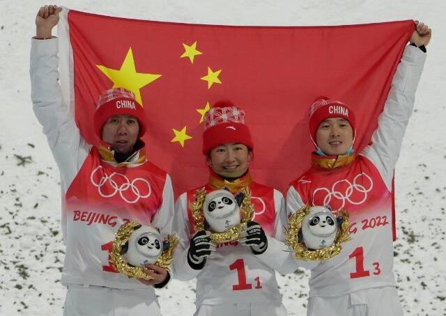 徐梦桃（中）、齐广璞（右）与贾宗洋在颁奖仪式上高举国旗庆祝。瞿芃摄