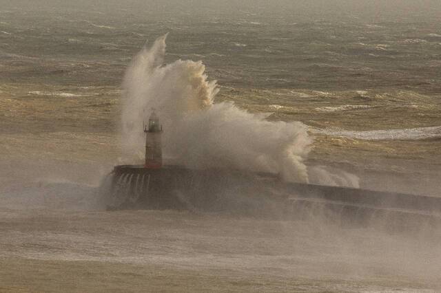 ↑2月18日，在英国纽黑文，巨浪拍打堤岸。新华社发（蒂姆·爱尔兰摄）