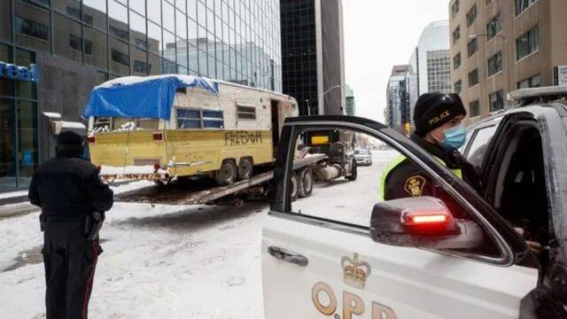20日，渥太华警察看着一辆露营车被拖走图源：CTV新闻网