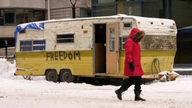 20日，渥太华一名居民走过市中心的一辆露营拖车图源：CTV新闻网
