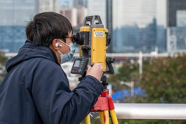 2022年2月23日，香港启德增建社区隔离及治疗设施，施工人员正在工地抓紧测量。人民视觉图
