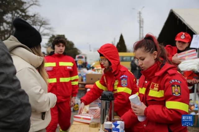 2月27日，在罗马尼亚北部与乌克兰接壤的锡雷特，工作人员为入境的乌克兰民众提供热饮。新华社记者林惠芬摄