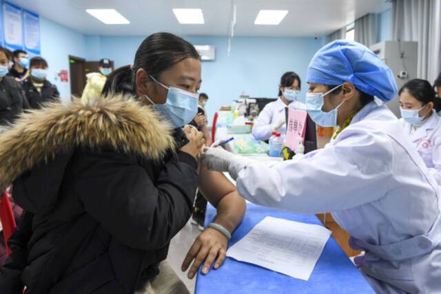 1月18日，生活在广西兴业县“老乡家园”的群众在小区对面的医院里接种新冠疫苗。新华社记者曹祎铭摄