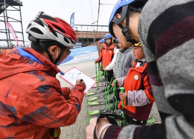 教练曹建（左一）在白板上画出滑降训练的路线（2月25日摄）。新华社记者王曦摄