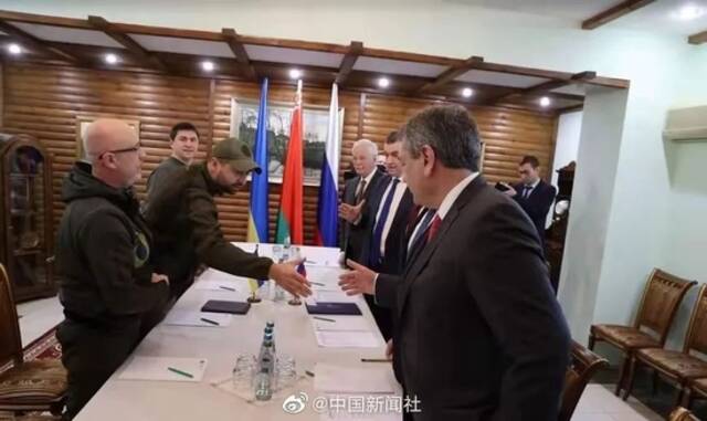俄罗斯代表团和乌克兰代表团的成员在会谈时相互握手。图源：中国新闻社微博