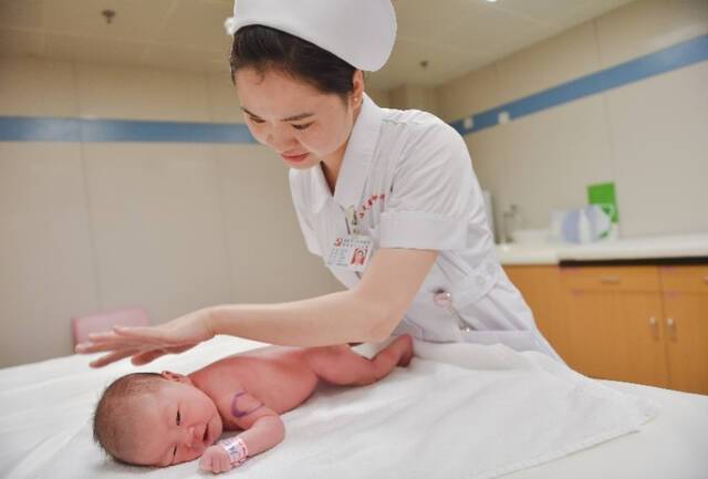 ▲在福建省妇幼保健院产科病房，护士在为新生儿抚触。图/新华社