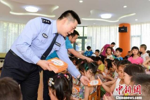民警向小朋友发放反拐常识画册。陕西警方供图