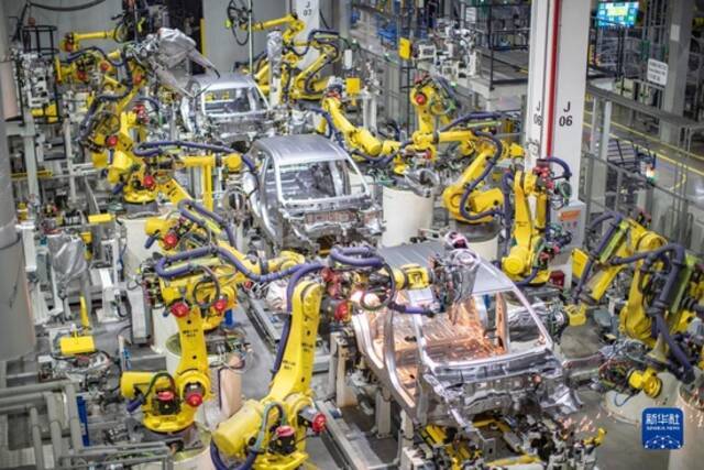 重庆一家新能源汽车企业使用智能化焊接机器人进行焊接作业（2021年4月2日摄）。新华社记者黄伟摄
