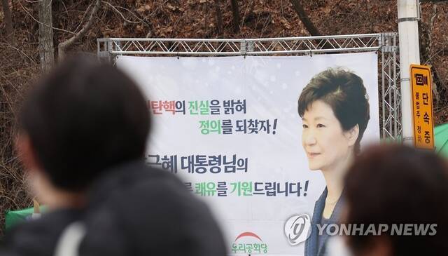 资料图：3月14日，在首尔江南区，三星首尔医院前悬挂着祝愿前总统朴槿惠早日康复的横幅。图源：韩联社